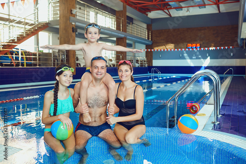 Plakat Szczęśliwa rodzina w basenie w pomieszczeniu.