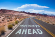 © Frank H. - The text 'Vacations ahead' written on a empty road in the desert of Nevada before the street turns right