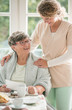 © Photographee.eu - Positive senior lady siting at table and smiling to her young nurse