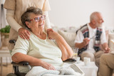 Fototapeta  - Happy senior lady sitting at wheelchair in nursing home for elderly