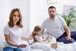 © LIGHTFIELD STUDIOS - worried parents sitting near sick daughter in bedroom and looking at camera