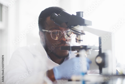Fotografía The scientist works with a microscope in a laboratory conducting experiments and formulas