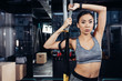© LIGHTFIELD STUDIOS - slim asian sportswoman holding resistance bands at gym