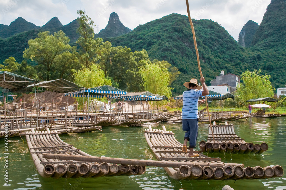 Traditional bamboo raft on Yulong River, Yangshuo, Guangxi, China. - obrazy, fototapety, plakaty 