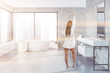 © ImageFlow - Concrete bathroom interior, tub and sink, woman