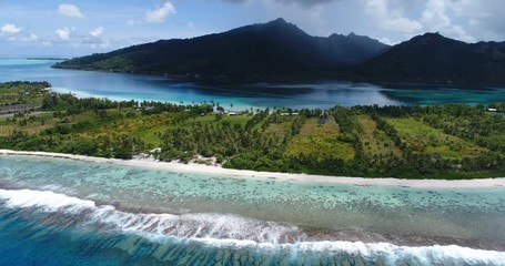 Wall Mural - Beautiful sea waves rushing towards beach shore. Amazing small island against mountains on sunny day. Tropical trees growing on landscape. Travel, vacation and summer holiday concept.