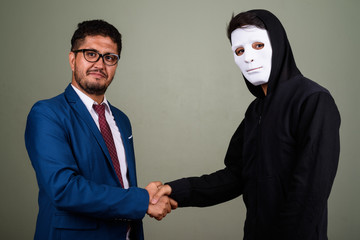 Bearded Persian businessman and young Indian man against colored