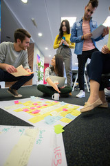 Wall Mural - Startup business people in modern office. Group of young business people are working together with laptop. Freelancers sitting on the floor. tech startup, tech team.