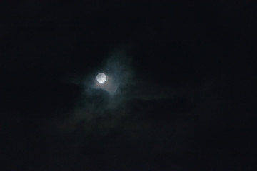 full moon behind clouds