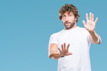 Wall Mural - Handsome hispanic model man over isolated background afraid and terrified with fear expression stop gesture with hands, shouting in shock. Panic concept.