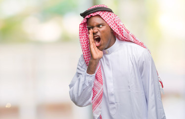 Poster - Young arabic african man wearing traditional keffiyeh over isolated background shouting and screaming loud to side with hand on mouth. Communication concept.