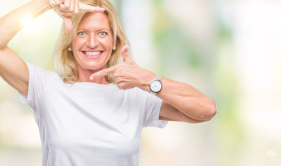 Canvas Print - Middle age blonde woman over isolated background smiling making frame with hands and fingers with happy face. Creativity and photography concept.