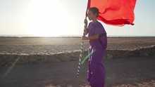 Child On A Stilts Make Show With Red Flag At Sunset Shaky Footage Slow Motion