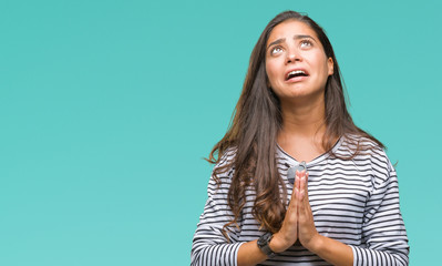 Wall Mural - Young beautiful arab woman wearing sunglasses over isolated background begging and praying with hands together with hope expression on face very emotional and worried. Asking for forgiveness