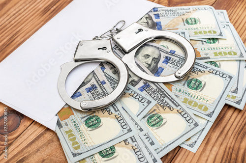 Fotografía Envelope with money and handcuffs on the table.
