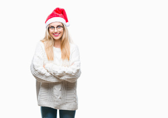 Young beautiful blonde woman wearing christmas hat over isolated background happy face smiling with crossed arms looking at the camera. Positive person.