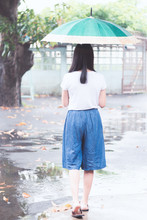 Asian Woman Standing In Rain Drops With Holding Umbrella
