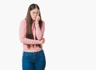 Sticker - Young Chinese woman over isolated background wearing glasses looking stressed and nervous with hands on mouth biting nails. Anxiety problem.