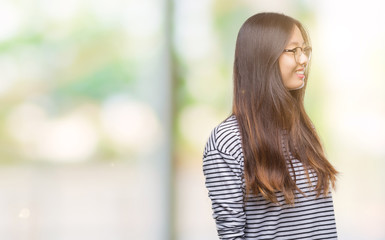 Sticker - Young asian woman wearing glasses over isolated background looking away to side with smile on face, natural expression. Laughing confident.