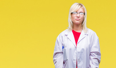 Canvas Print - Young beautiful blonde professional woman wearing white coat over isolated background with serious expression on face. Simple and natural looking at the camera.