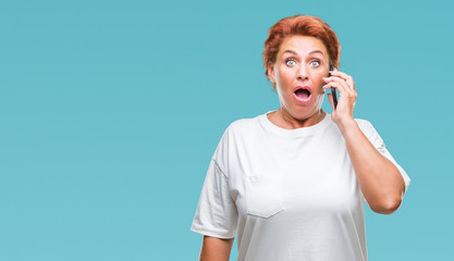 Sticker - Atrractive senior caucasian redhead woman talking on smartphone over isolated background scared in shock with a surprise face, afraid and excited with fear expression