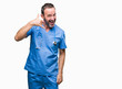 © Krakenimages.com - Middle age hoary senior doctor man wearing medical uniform over isolated background smiling doing phone gesture with hand and fingers like talking on the telephone. Communicating concepts.