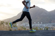 © wayhome.studio - Healthy dark skinned man in action, runs along road near mountains, wears comfortable sneakers, casual clothes, has sporty body. Fast male athlete poses against sky background. Racing competition