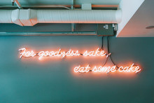 A Neon Sign That Says To Eat Some Cake. 