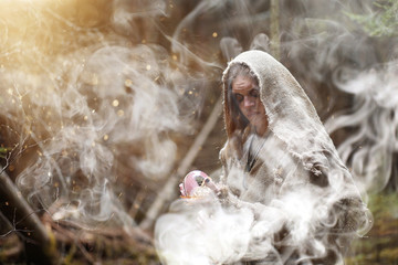 Wall Mural - A man in a cassock spends a ritual in a dark forest