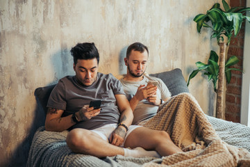 Wall Mural - Two homosexual male friends enjoy resting together, have positive expressions, make selfie photo, share pictures in social networks.