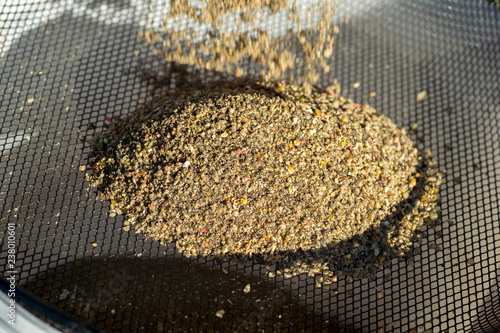 Fotografía Sieving fishing bait through a sieve to prepare a homogeneous mass to attract fi