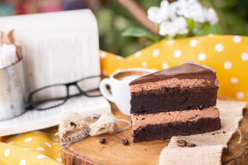 Coffee mousse chocolate cake with book, glasses decoration on wood plate