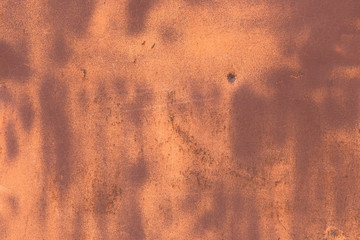 Spots of old paint on a rusty metal surface.