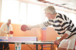 © pressmaster - One of ping pong players hitting ball while passing it over table to his mate during game in the hall