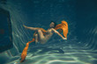 cute sporty girl swims underwater as a free diver in lingerie and mesh catsuit with rhinestones alone