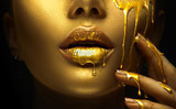 Fototapeta  - Golden paint smudges drips from the face lips and hand, golden liquid drops on beautiful model girl's mouth, creative abstract makeup. Beauty woman face