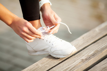  Fitness. Close up female runner is tying her shoelace