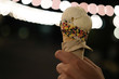 Hand holding vanilla ice cream in night