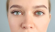 Young woman with beautiful eyelashes on gray background, closeup. Before and after extension procedure