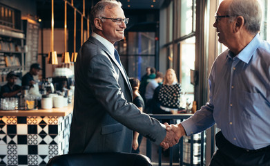 Wall Mural - Businessmen handshake in a modern restaurant