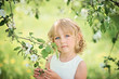 © Serenkonata - girl sniffing flowers of apple orchard. garden with flowering trees