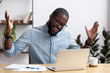 © fizkes - Joyful black businessman sitting at desk looking at computer screen talking with friend make informal video call. African worker received great news read email feels happy getting reward or promotion