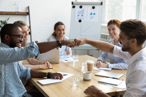 Cuadros en Lienzo Diverse company staff girls guys sitting at desk in boardroom feel happy and satisfied celebrating success at work