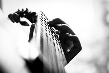 Closeup view of musician playing acoustic guitar.