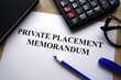 Private placement memorandum document, pen, glasses and   calculator on desk