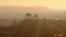 Cinematic Aerial Of Griffith Observatory With  The Hollywood  Sign As Background / Los Angeles, California 