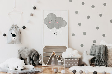 Stylish scandinavian newborn baby room with toys, teddy bears, cotton lamps and cloud. Modern interior with mock up photo frame. White background walls with dots pattern.