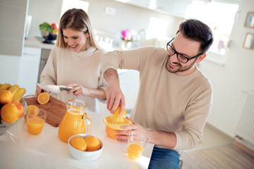 Poster - Couple with orange juice in the kitchen