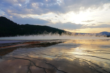 Wall Mural - Fiery orange sunset over the Grand Prismatic pool in Yellowstone National Park, United States