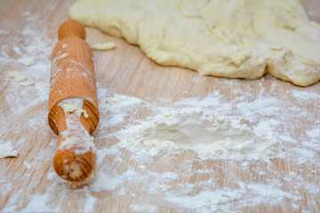 Rolling pin in the dough close-up, gluten-free flour and dough. Cooking healthy diet baking at home.